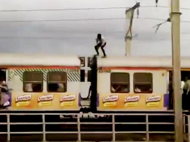 Boy takes video standing on top of train